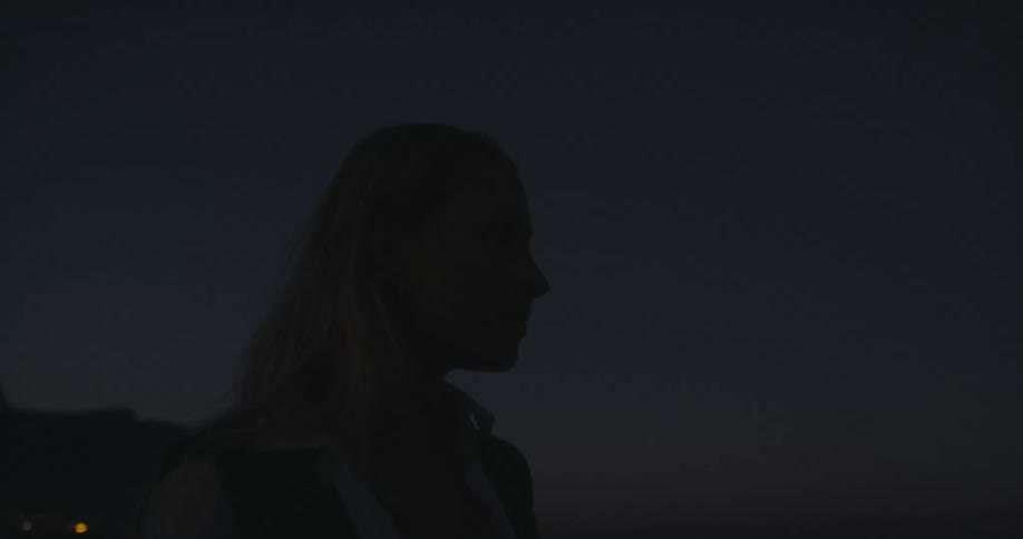 A woman is standing in the dark