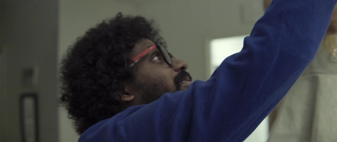A man and a woman stand in a room adjusting something above them