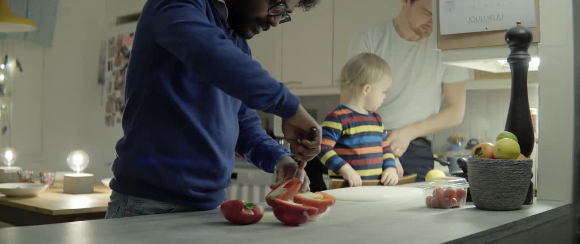 Happy family preparing a healthy meal together in a bright modern home kitchen setting.