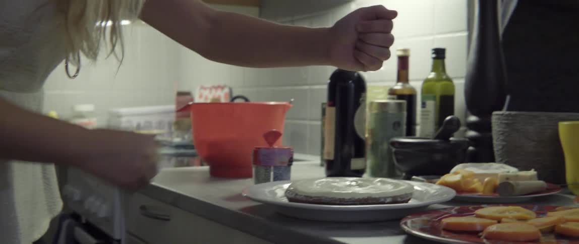 Woman Adding Colorful Sprinkles to a Dessert With Joyful Care in a Bright Kitchen.