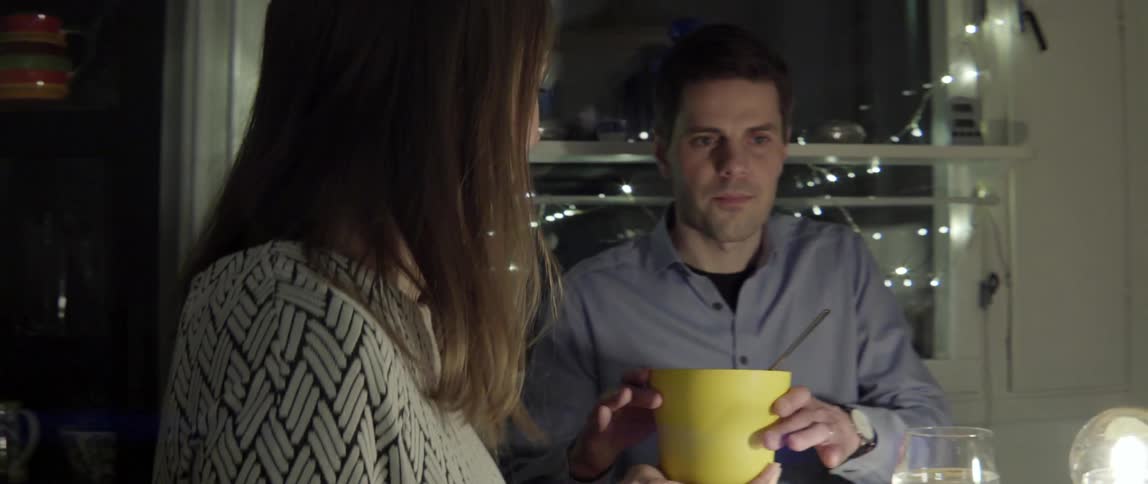 People talk while passing around food at a dining room table