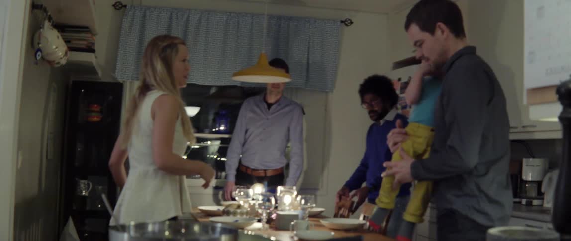 A group of people gather around a dining room table to eat