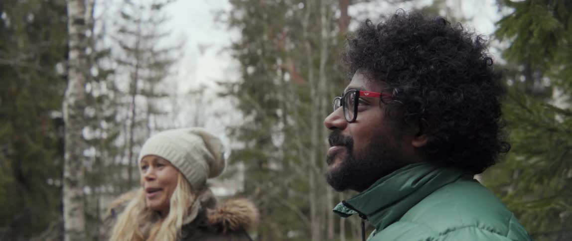 Man and woman talking outside while looking at a tree with relaxed nature vibe