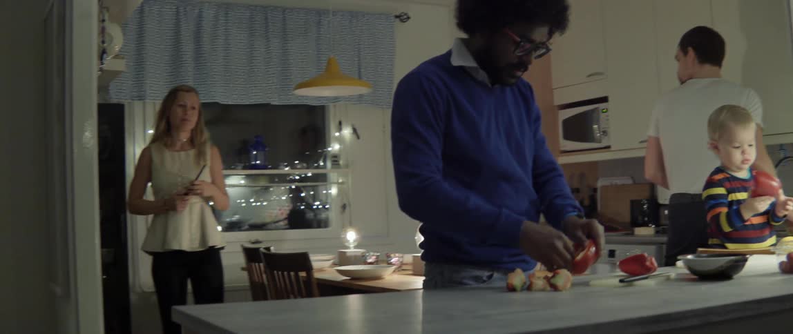 People gather in a kitchen and dining room to cook dinner
