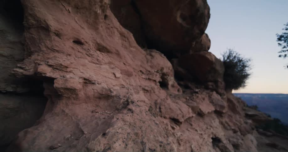 A cave is revealed on a sheer rock cliff in a canyon