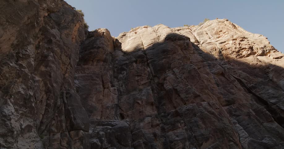 Sunlight shines on top portion of escarpment as the bottom remains in shadow
