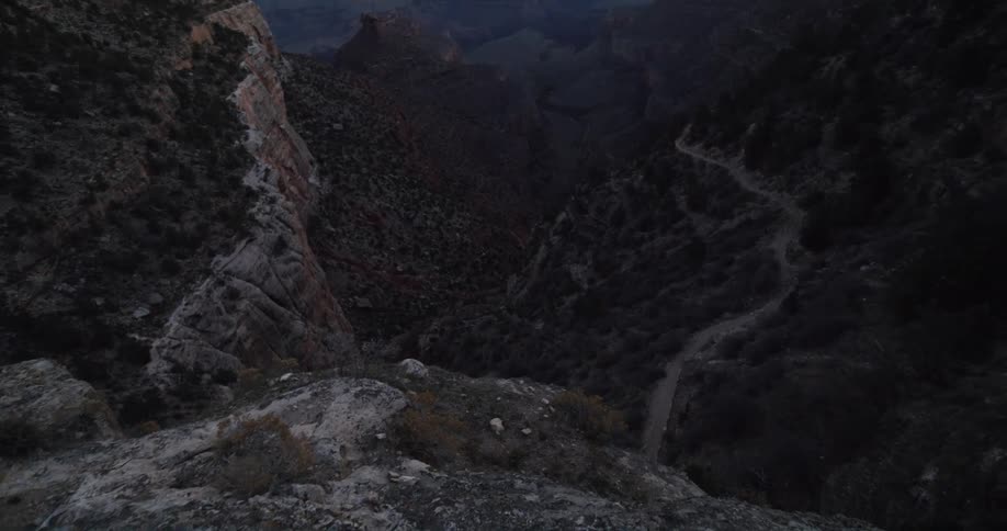 River flows from base of cliff and deeper into misty valley