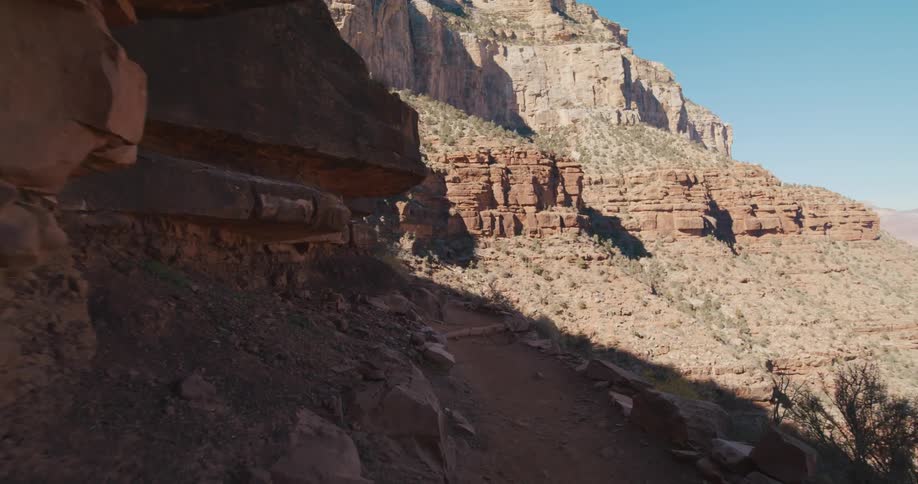 A steep red rock mountain range on a clear and sunny day