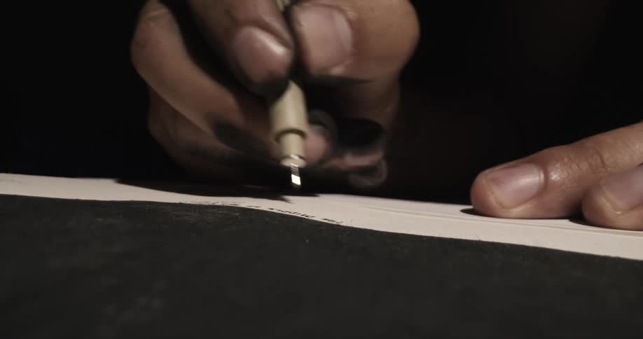 Artist with ink stained fingers prints on paper
