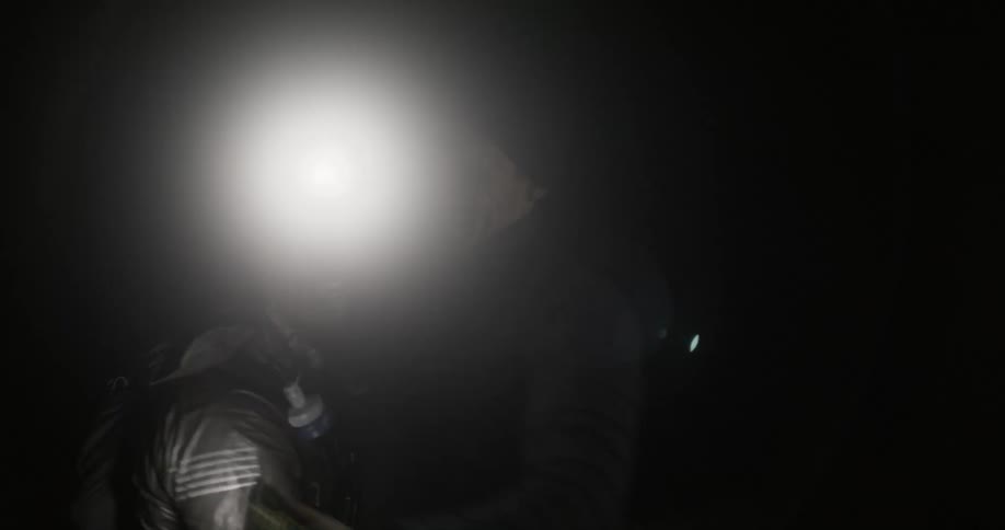 Two men hug and smile outside at night