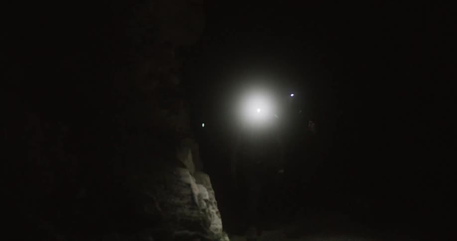 People are walking through the dark cave
