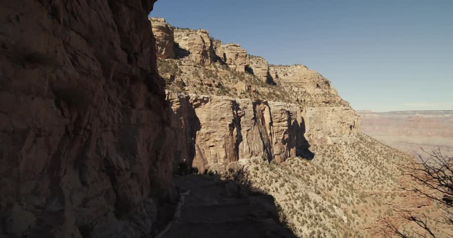 A narrow walkway along the side of a butte during the day