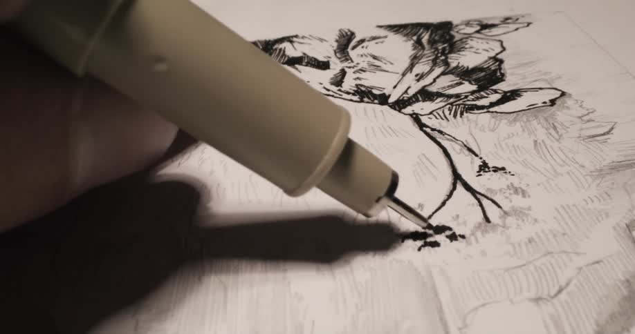 Artist inks sketch with black ink