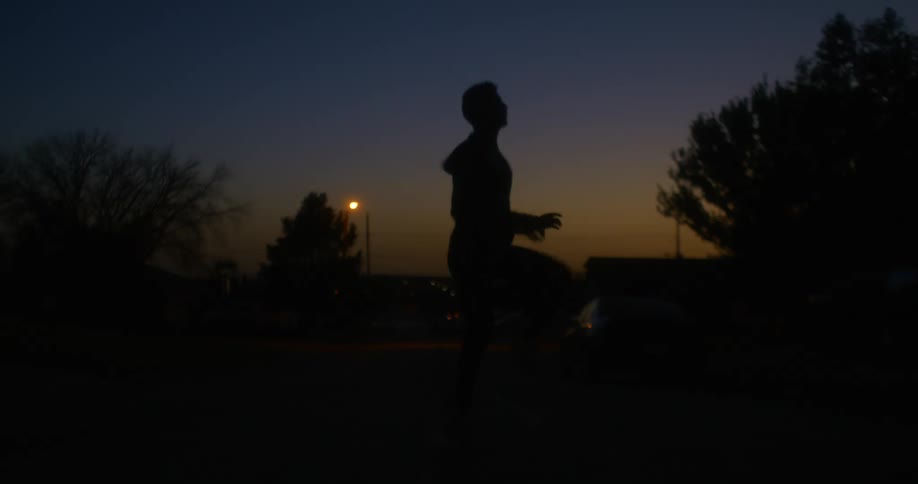 A man jogs in place outside in a neighborhood