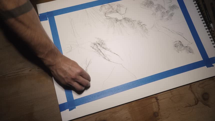 A person is drawing on a piece of paper indoors
