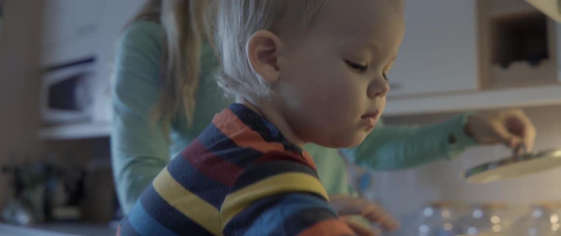 Heartwarming domestic scene of a mother and son organizing ingredients in a modern kitchen.