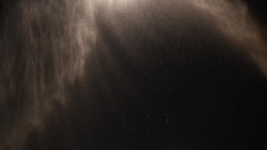 Illuminated water sprays through the air in the darkness