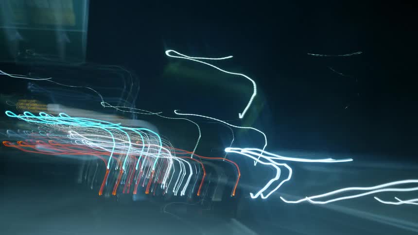 Streaks of light flow rapidly across dark background