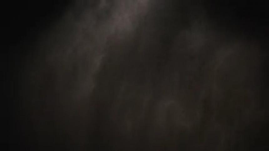 White particles hanging in air in dark area slowly dissipate