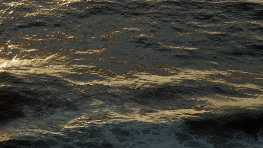 The sun shines on ocean water as it ripples and waves