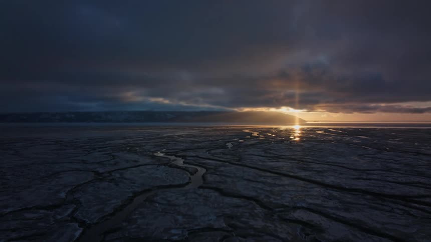 The sun is setting in the horizon of the landscape