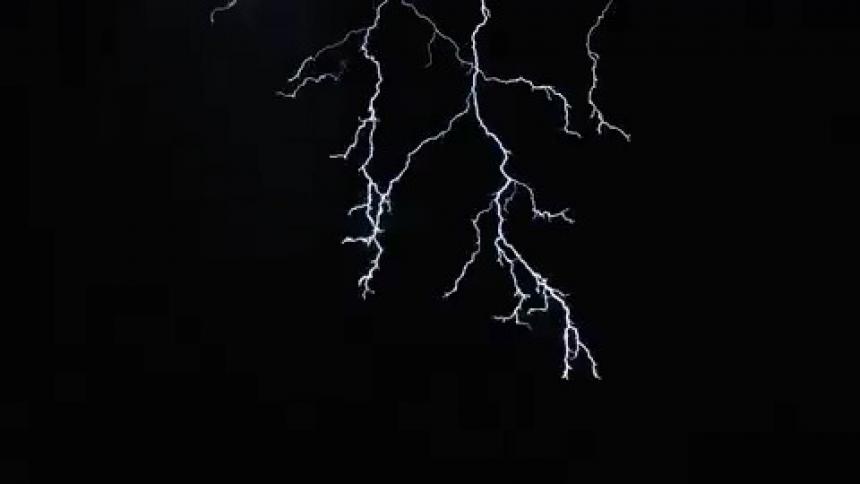 A lightning bolt spreads through the sky and hits the ground