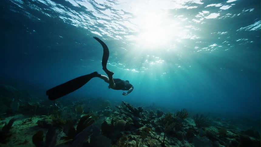 A man swimming under water in the ocean