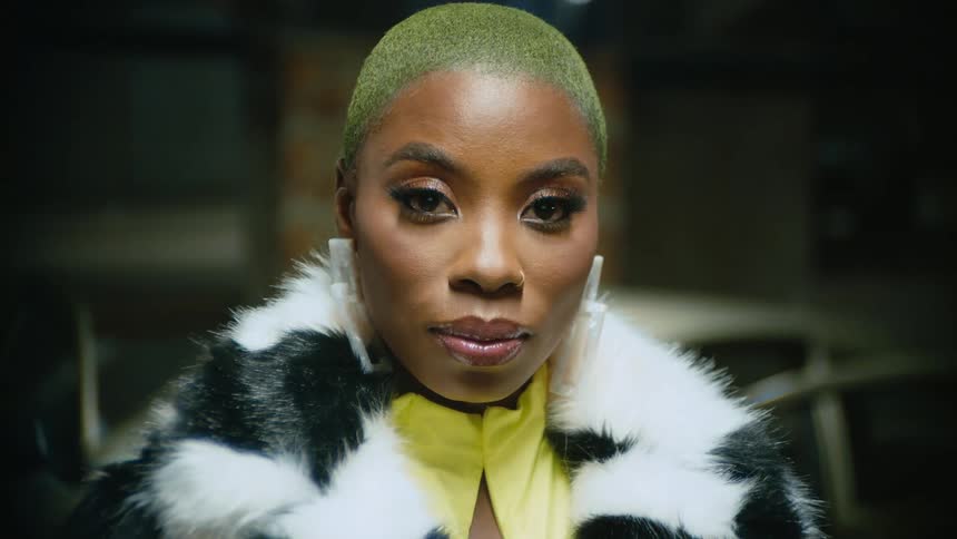 A woman in fashionable clothing gazes into the camera