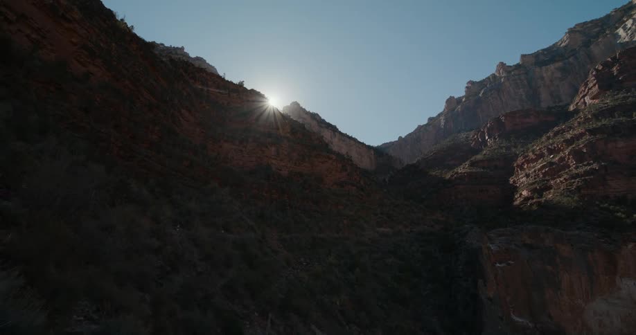 Sun peeks out from the top of a mountain