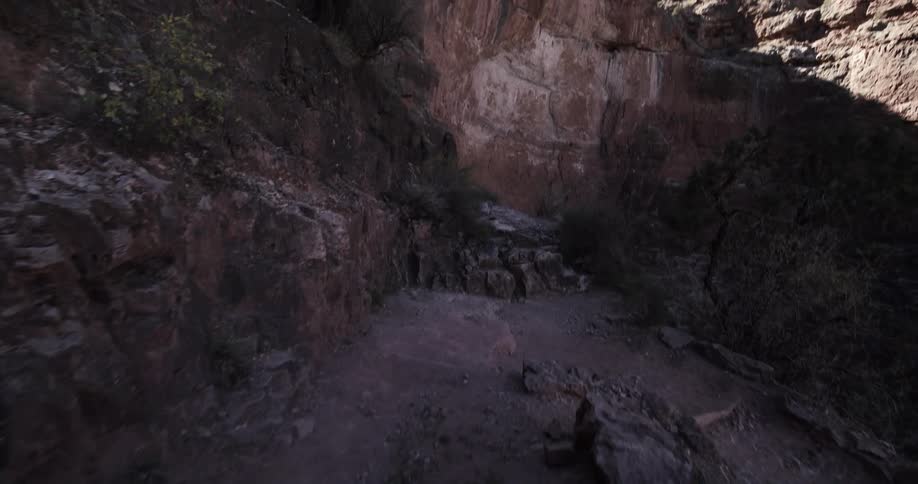 A narrow walkway along the wall of a canyon during the day