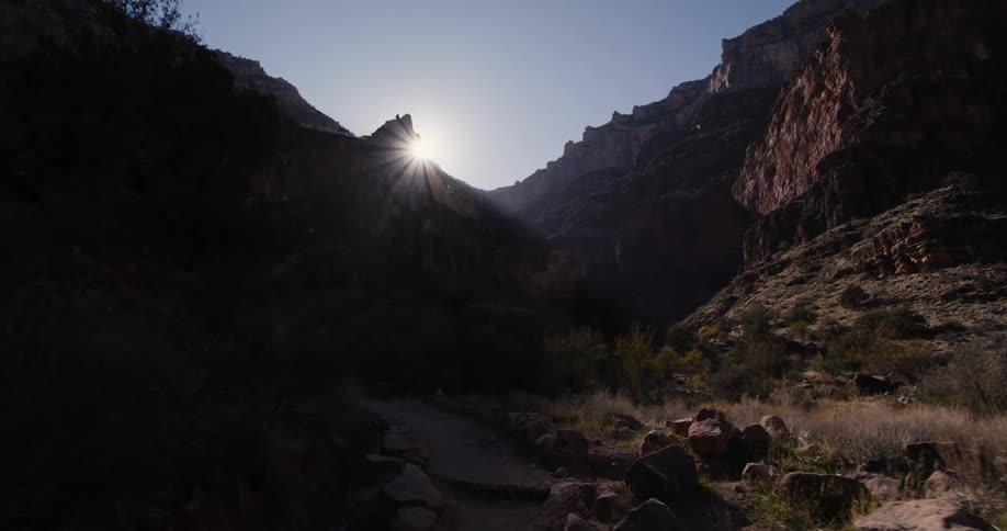 A narrow path along the bottom of a canyon during the day