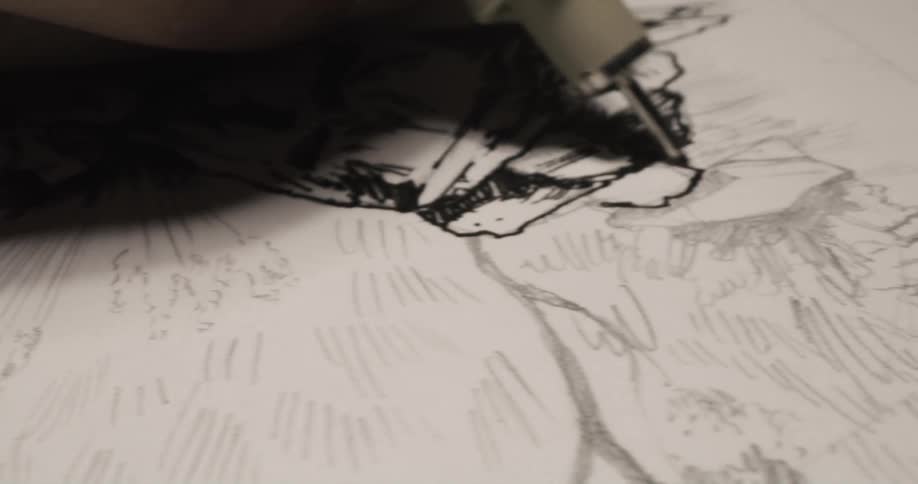 An artist is inking a sketch with a black pen