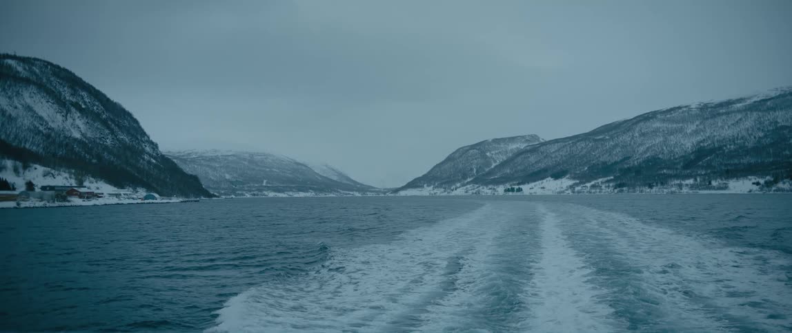 View of waves in an ocean and mountains from a boat