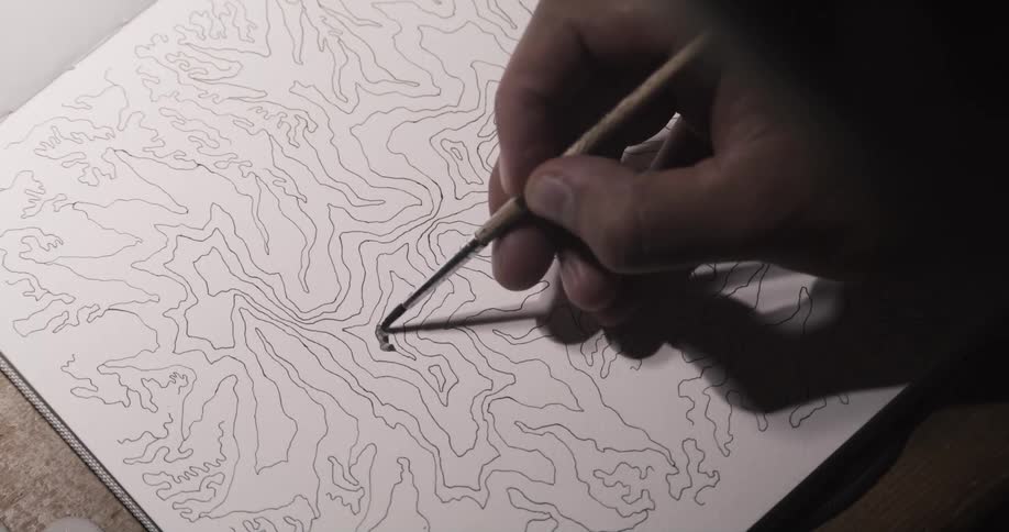 An artist is painting a black and white line drawing