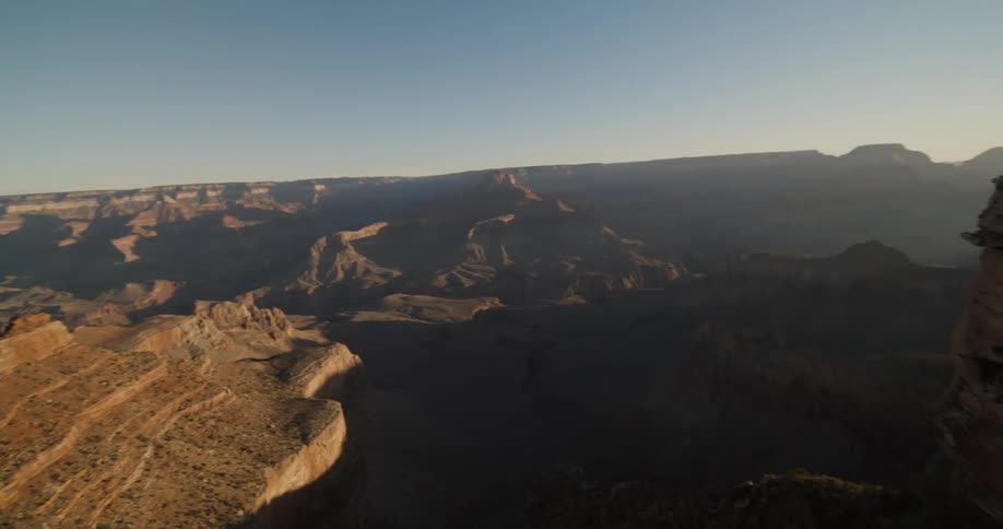 A vast canyon under a clear daytime sky