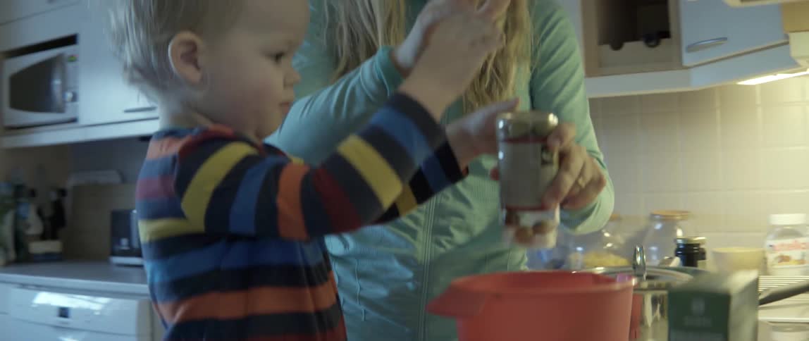 domestic scene of a parent and child bonding over a home-cooked meal activity.