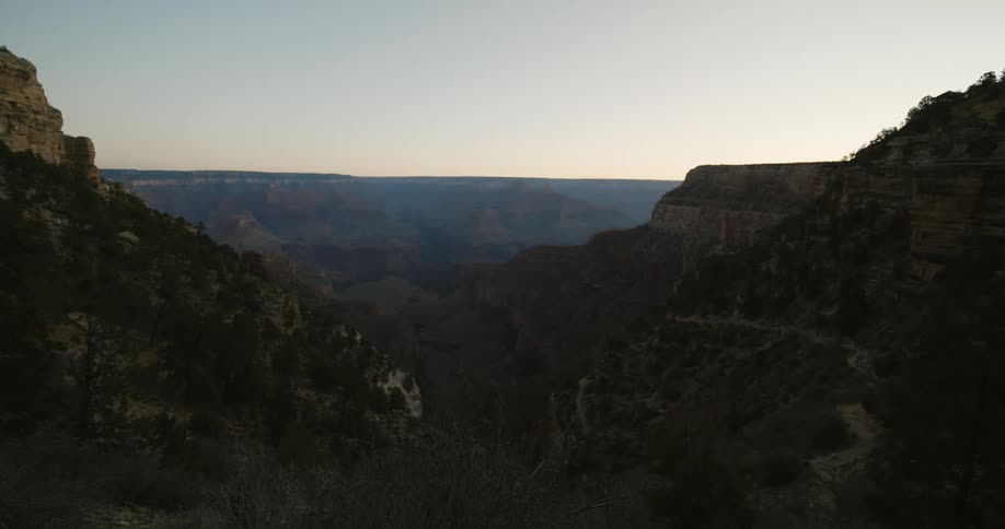 A haze is settled over a canyon as the sun rises
