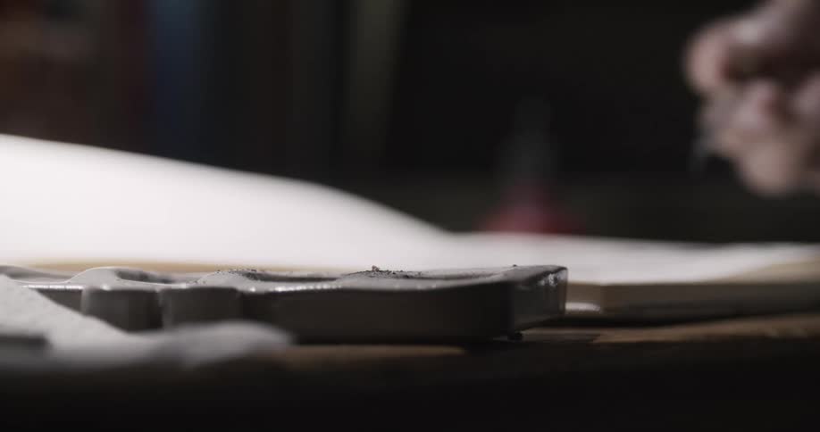 An artist loads their brush up with more paint then moves the brush to the paper
