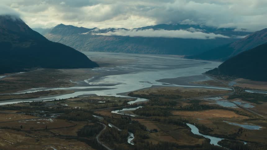 Rivers wind through the floor of a mountain valley during the day
