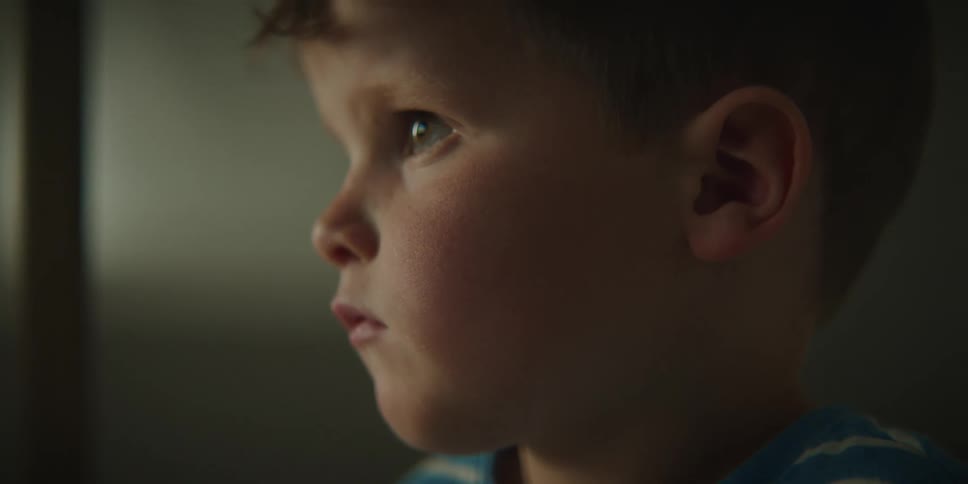A little boy is watching something with his full attention