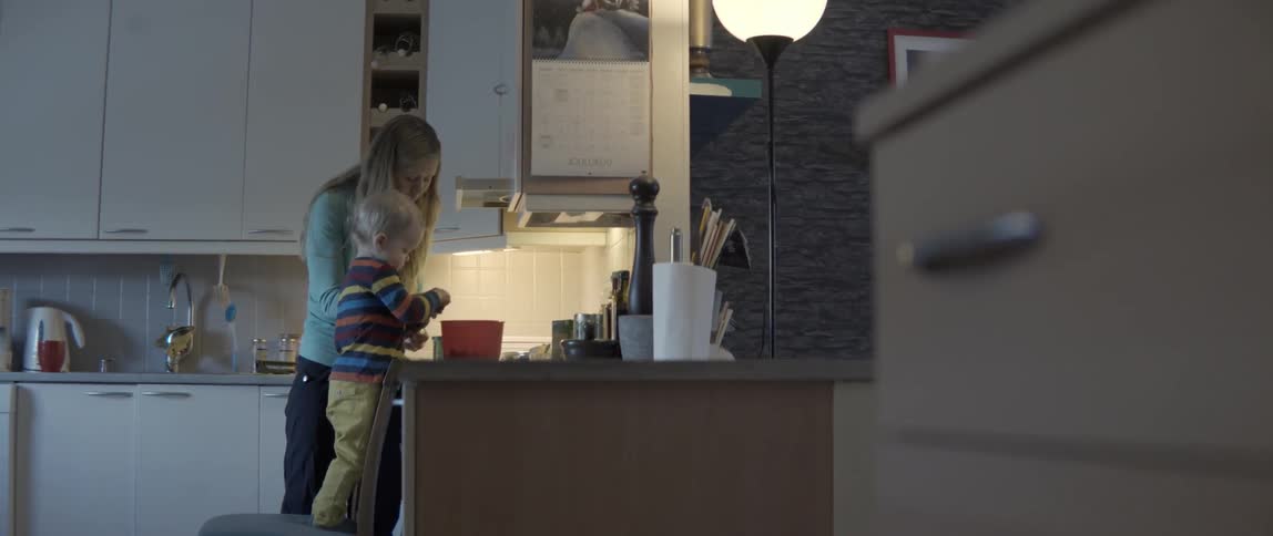 Young mother and small boy preparing a home-cooked meal in a bright contemporary kitchen