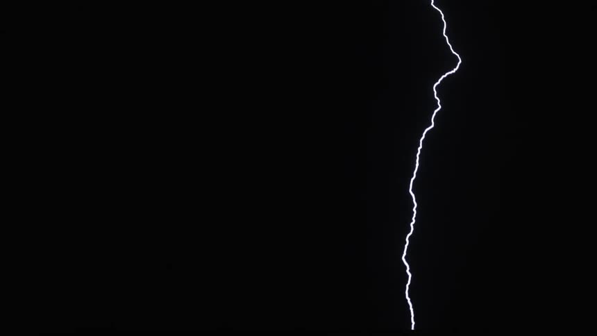 Lightning cracks across a dark night sky and hits the ground