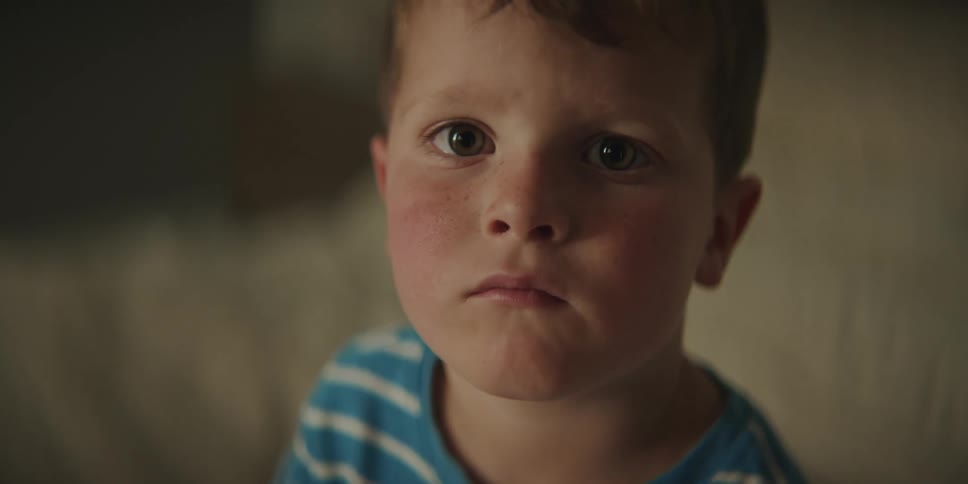 A red faced little boy looks sad