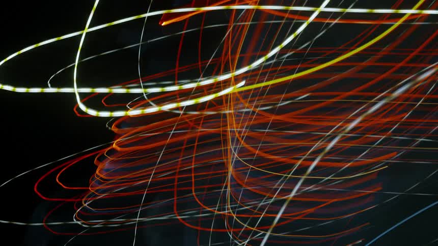 Lines of lights in many colors make a pattern in the darkness