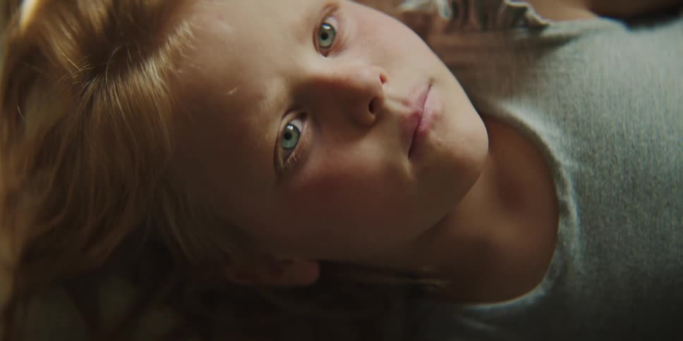 A little girl lying down deep in thought