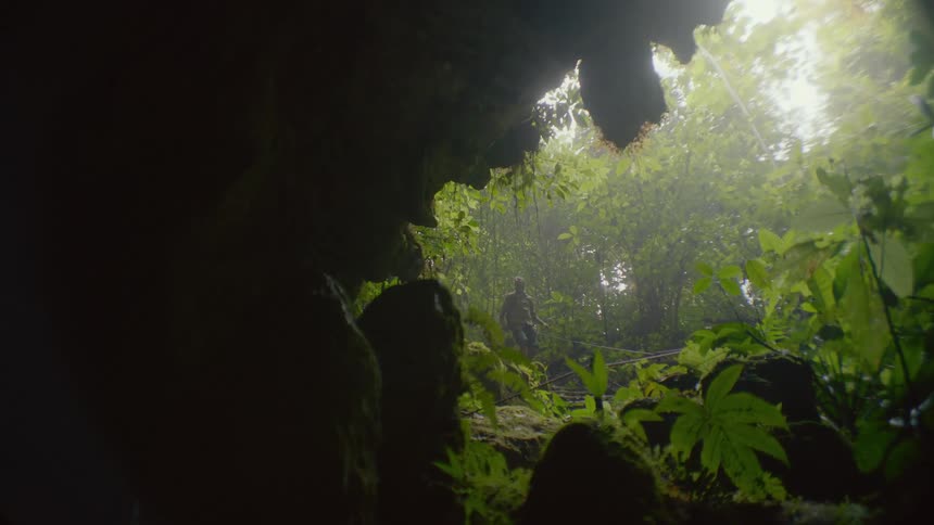 A man is hiking by the cave