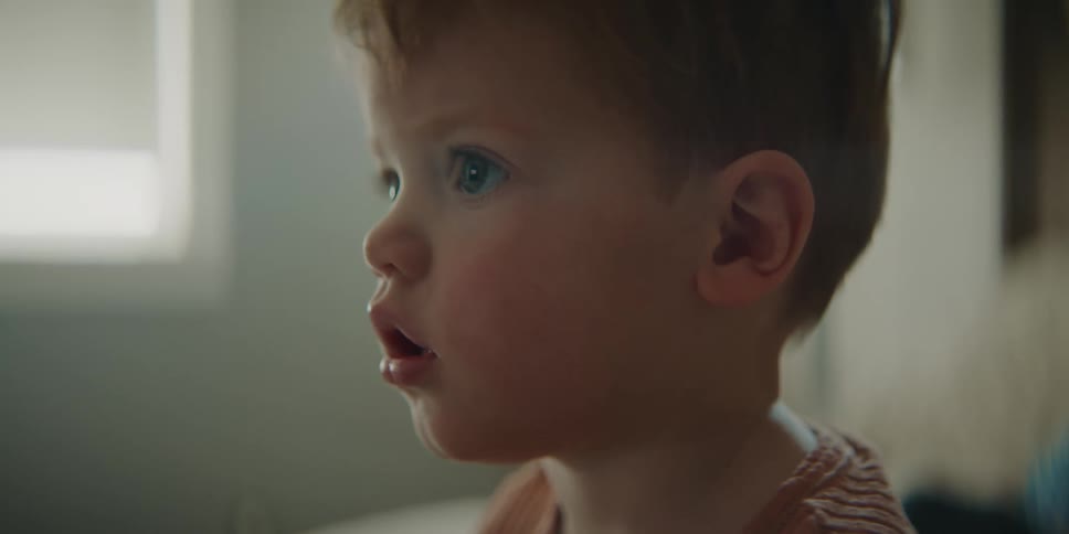 A young boy is sitting in a room watching something