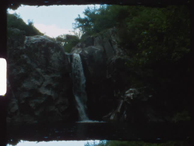 A small waterfall down a cliff in the wilderness during the day
