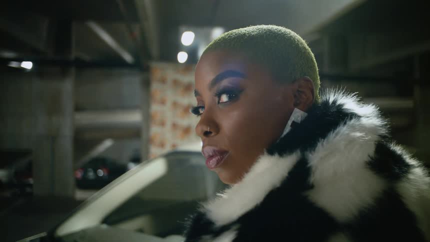 A woman turns her head in the parking garage