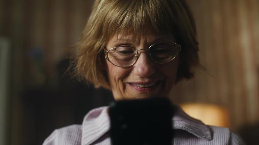 Middle aged woman smiles while talking on a video call